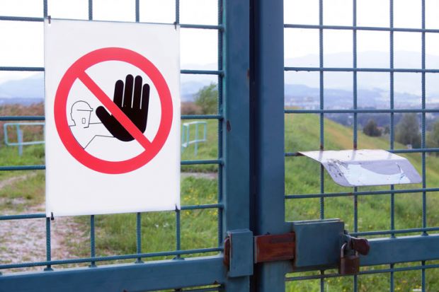 'No admission' sign on gated fence