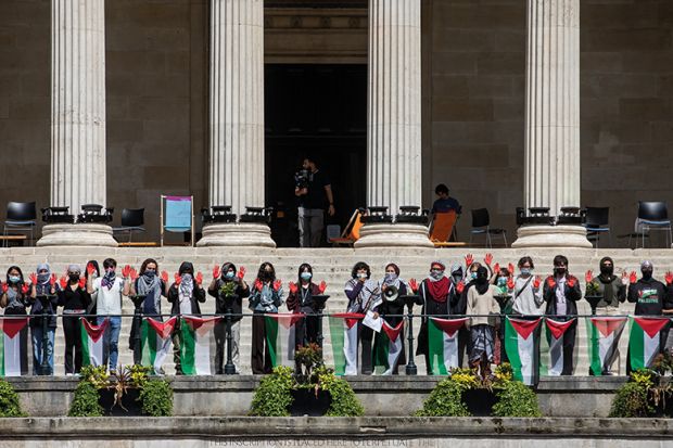 Students from UCL hold up hands painted red during a pro-Palestinian rally, 2024