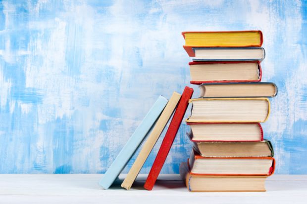 A stack of book beside a blue wall