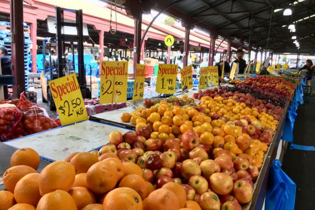 Melbourne, Australia April 12, 2018 People browse the fruit and vegetable stalls at Queen Victoria Market in Melbourne. Prices are displayed over the fruit.