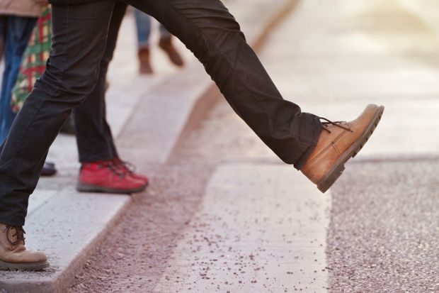 Person stepping onto pedestrian crossing