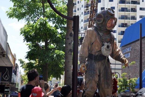 Perth,WA,Australia-February 14,2015 Giant marionette diver and spectators at the Perth International Arts Festival, Journey of the Giants, in Western Australia.