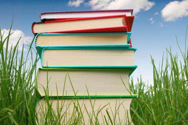 Pile of books on grass, summertime