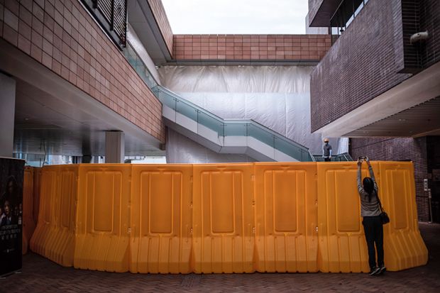 A visitor takes photographs of the "Pillar of Shame" statue site after its removal from the University of Hong Kong (HKU) on December 23, 2021