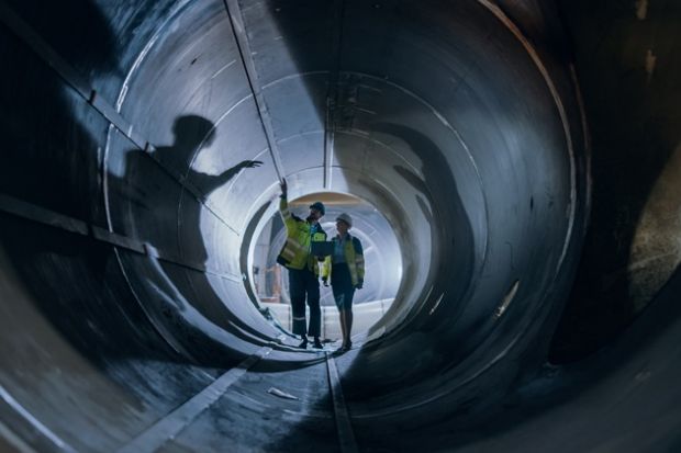 Two engineers walking inside a large pipe, symbolising the skills pipeline