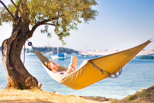 A person reading in a hammock