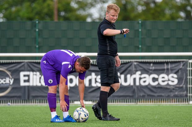 A referee looks at his watch before the kick off of a football match, illustrating that dozens of higher education institutions are to publish their accounts late.