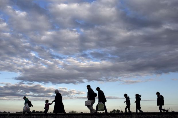 Refugees walking across a field