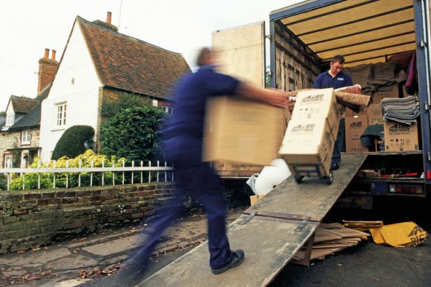 Removal men loading home contents into truck