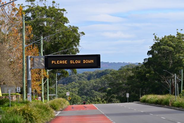 Road safety sign saying please slow down