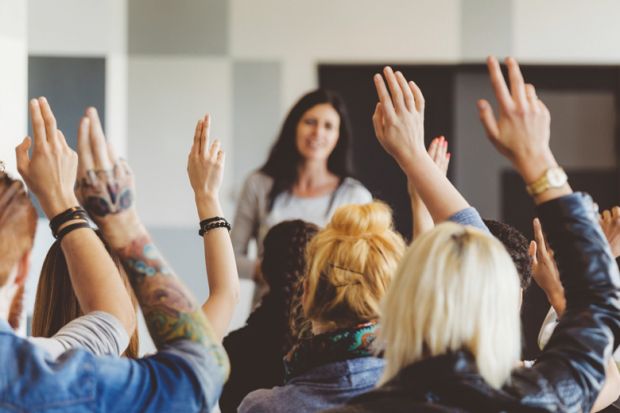 Students raising hands during lecture