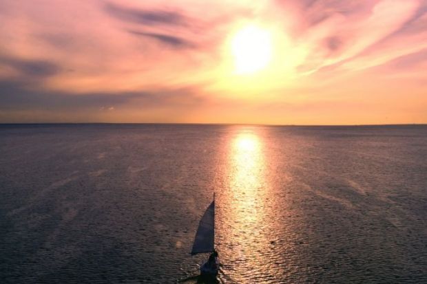 A yacht sailing into the sunset, illustrating retirement