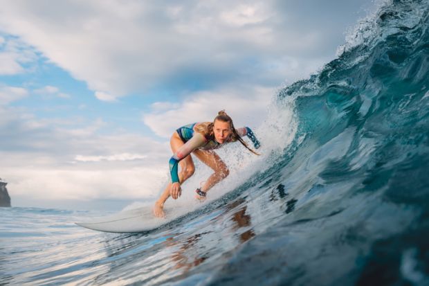 A woman surfing a large wave