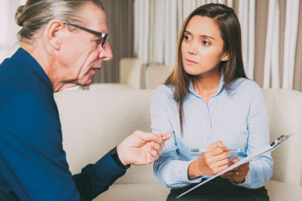 A woman with a clipboard interviews a man 