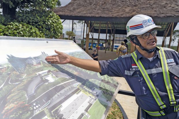 A worker shows an artist rendition of the country's new capital Nusantara to illustrate Doubts over higher education vision for Indonesia’s new capital