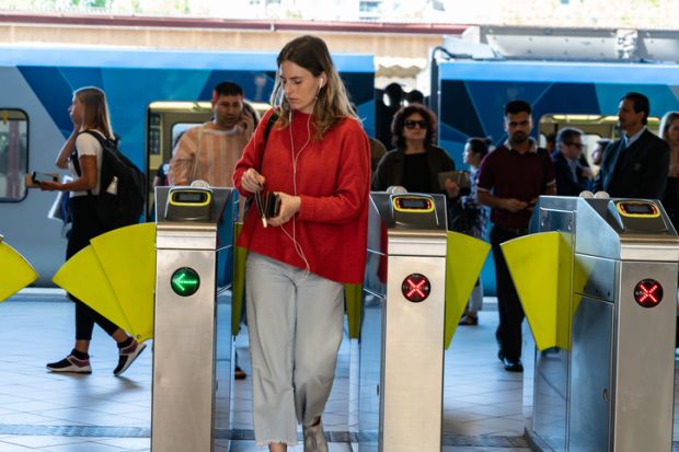 A woman passes through tunstiles at a commuter rail staition in Melbourne, symbolising open access