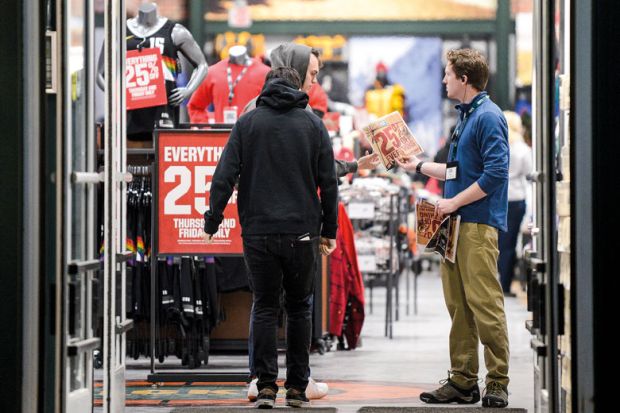 Shopper offered 25% off leaflet in a store entrance to illustrate US colleges get new challenge on tuition fee discounts