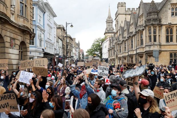 Protestors hold placards and shout slogans during during a protest 