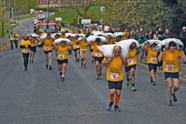 Competitors take part in the Men’s Veterans’ Race at the annual World Coal Carrying Championships to illustrate PhDs for everyone will not improve academia