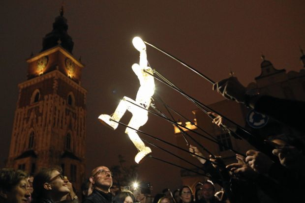 Puppet artists of the performance group Dundu move a puppet on the Main Square in Cracow, Poland to illustrate Scientists fear creeping political influence over Polish academy