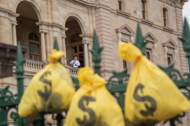 Money bags hang on a fence of the Queensland Parliament  to illustrate Record makes v-c paid