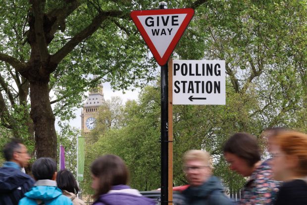 People walk near a polling station direction sign ahead of local elections, in London, Britain to illustrate Reset required