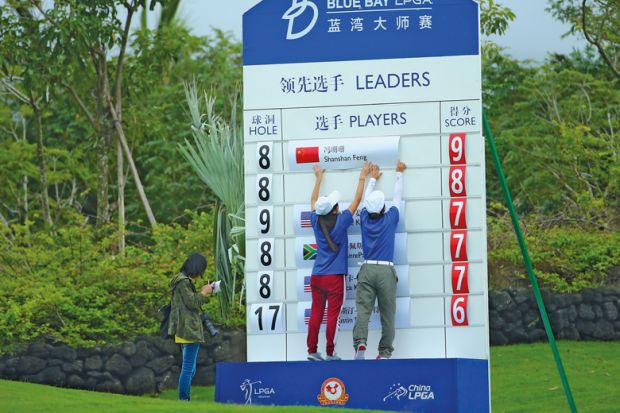 Scorers make a change on a scoreboard in Hainan Island, China to illustrate ‘Up-or-out’ systems heap pressure on junior academics in China