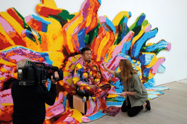 Artist Liu Bolin mid-way painting through his first live UK performance The Disappearing Act in London's Saatchi Gallery