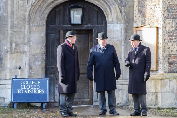 Trinity college at the University of Cambridge, England. Men standing at closed door with sign reading 'College to to visitors' to illustrate Elitism cannot be fixed without Oxbridge admissions reform