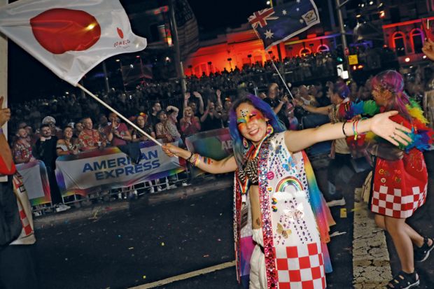 Person waving Japanese flage in Sydney Australia at the annual  Sydney Gay and Lesbian Mardi Gras Parade to illustrate Japan moves cautiously on overseas branch campuses