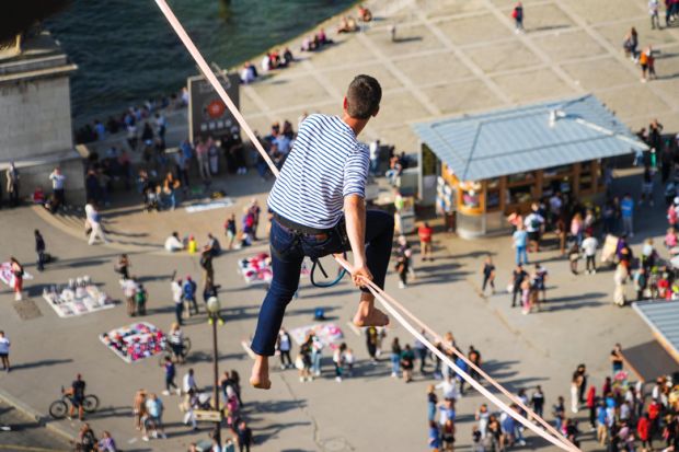 Tightrope walker Nathan Paulin traverses a slackline between the Eiffel Tower and the Trocadero Square to illustrate French universities avoid worst in election but face uncertainty