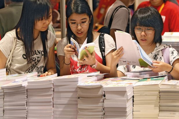 Visitors browse books on the first day of opening of book fair to illustrate Universities seek to overcome Chinese open access resistance