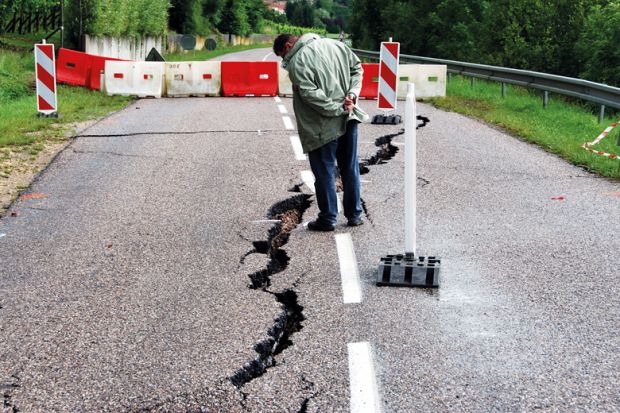  Passer by looking at cracks in the road  near Contz-les-Bains, Lorraine, France to illustrate Paris-Saclay crisis exposes cracks in mega-university project