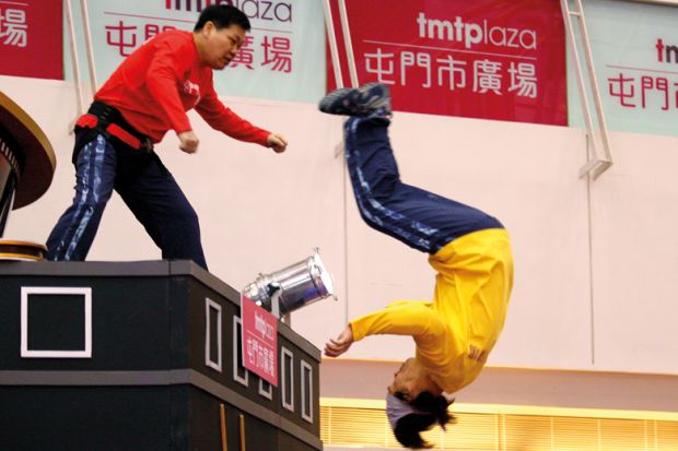 A stunt duo jump off a platform at Tuen Mun Town Plaza, China
