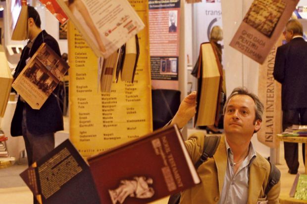 A man reads a book hanging at Earls Court Exhibition Centre in London to illustrate Don’t wait to tackle open access books cash challenge, REF told