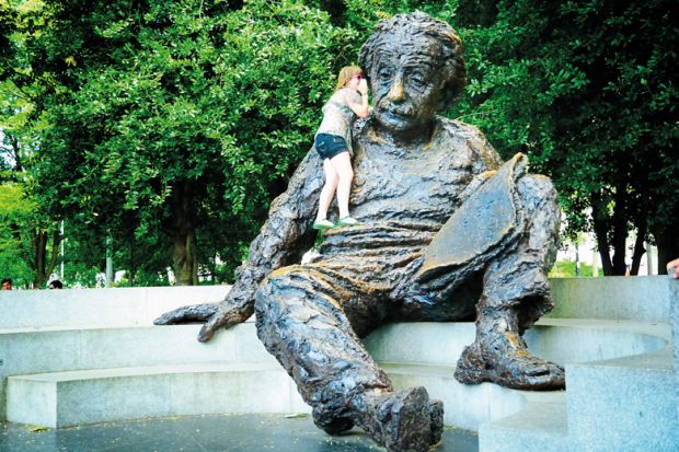 Person talking in the ear of the Einstein memorial inWashington D.C. to illustrate ‘Don’t fear’ waking giant of international education