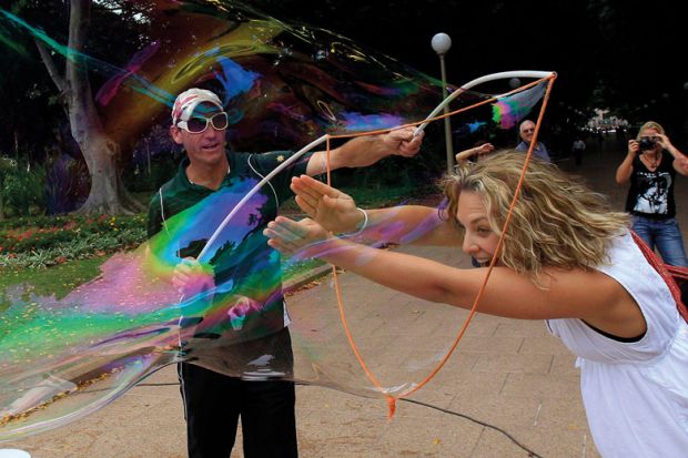 A volunteer puts her arms and head into one of the bubbles in Sydney's Hyde Park