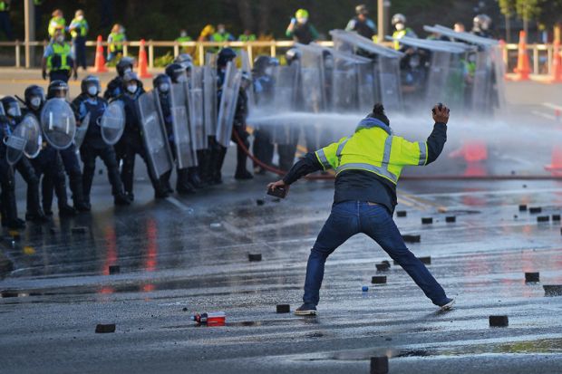 A man faces off with police near the parliament as police move in to clear protesters in Wellington to illustrate We need support as threats worsen, says scholar who sued Auckland