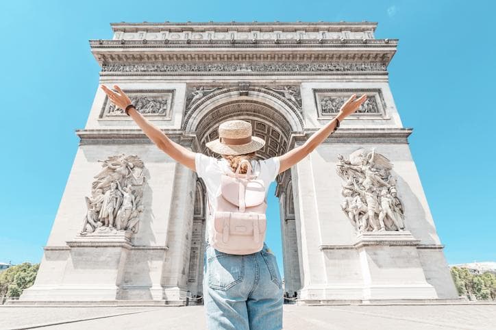 tourist girl enjoys the view of the majestic and famous Arc de Triomphe